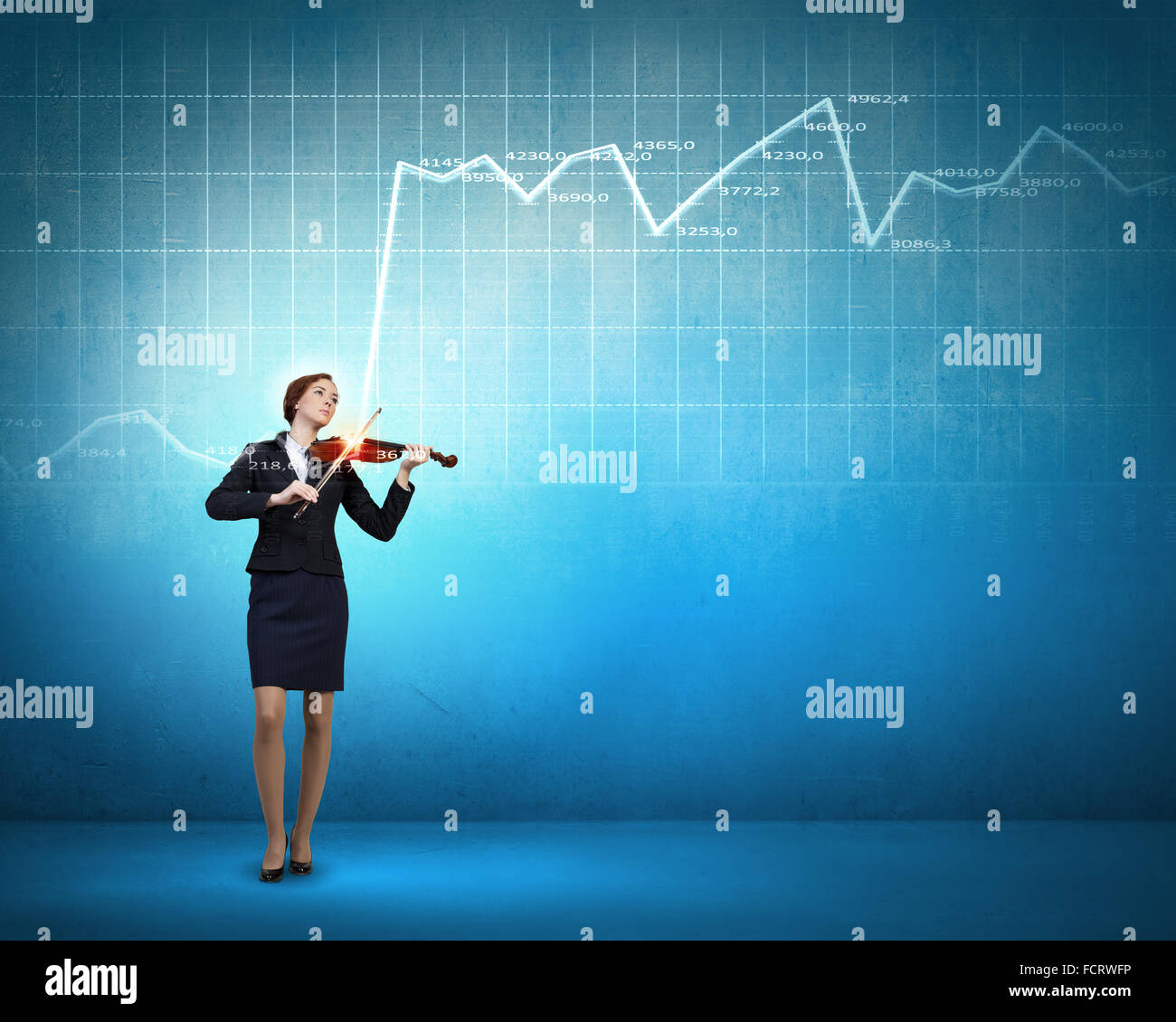Young businesswoman playing violin and financial graphs at background ...