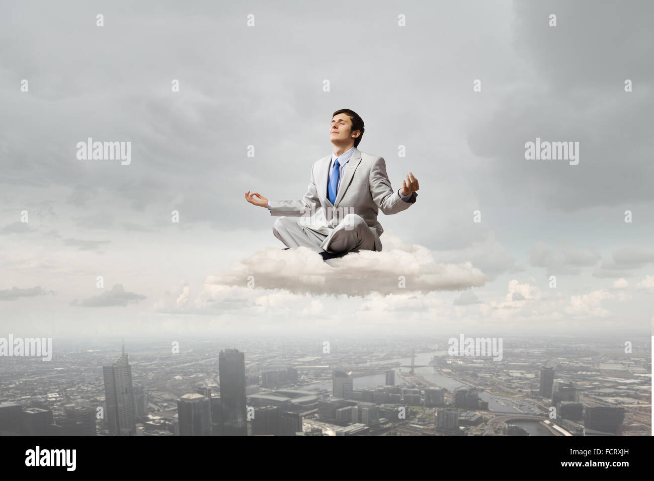 Young businessman sitting on cloud high in sky and meditating Stock ...