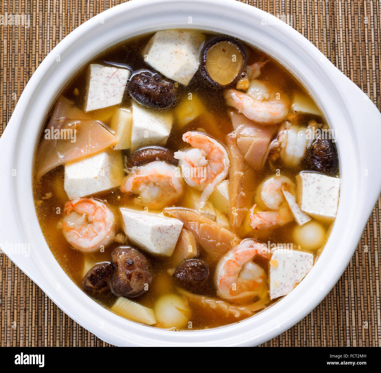 High angled view of Asian soup consisting of shrimp, mushroom, tofu
