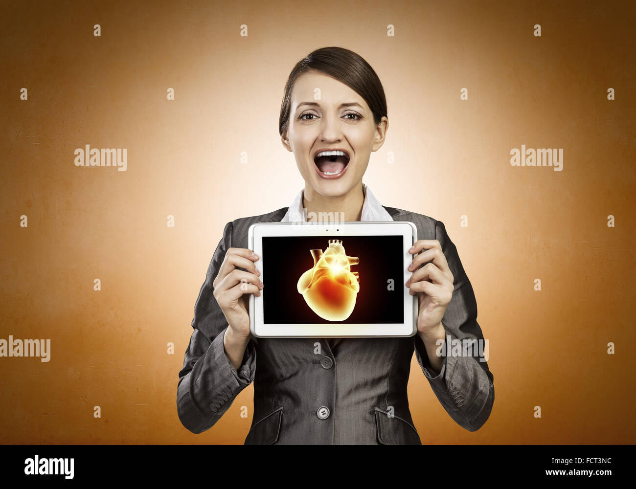 Young businesswoman showing tablet pc against heart Stock Photo