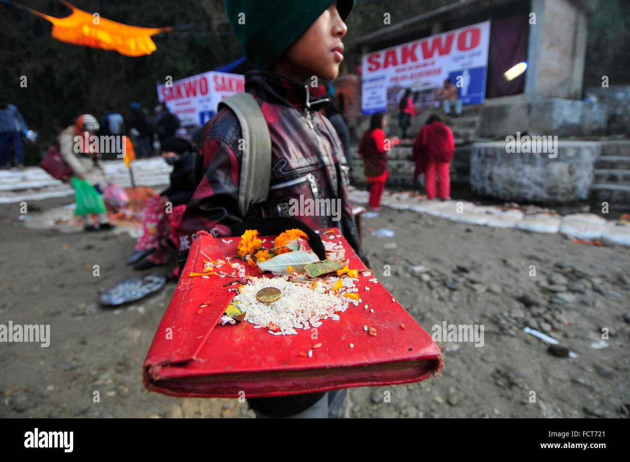 Kathmandu, Nepal. 24th Jan, 2016. A kid carries holy book of Swasthani Barta Katha during the first day of Madhav Narayan Festival at Sankhu. Nepalese Hindu women observe a fast and pray to Goddess Swasthani for Long life of their husbands and family prosperity during a month-long fasting festival celebration. © Narayan Maharjan/Pacific Press/Alamy Live News Stock Photo