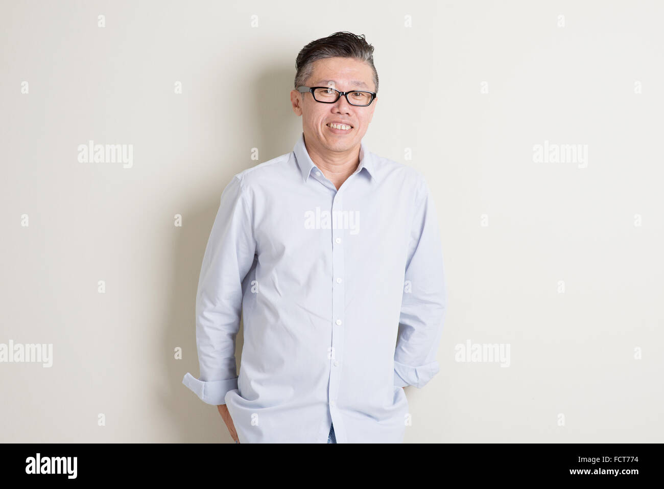 Portrait of single mature 50s Asian man in casual business arms crossed ...