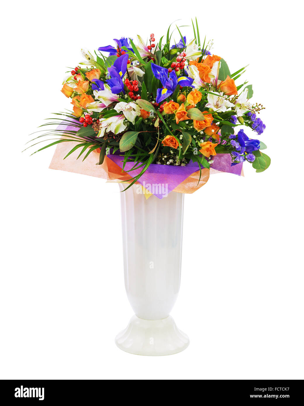 Delicate beautiful bouquet of roses, iris, alstroemeria, nerine and other flowers with colored packaging in vase solated on whit Stock Photo