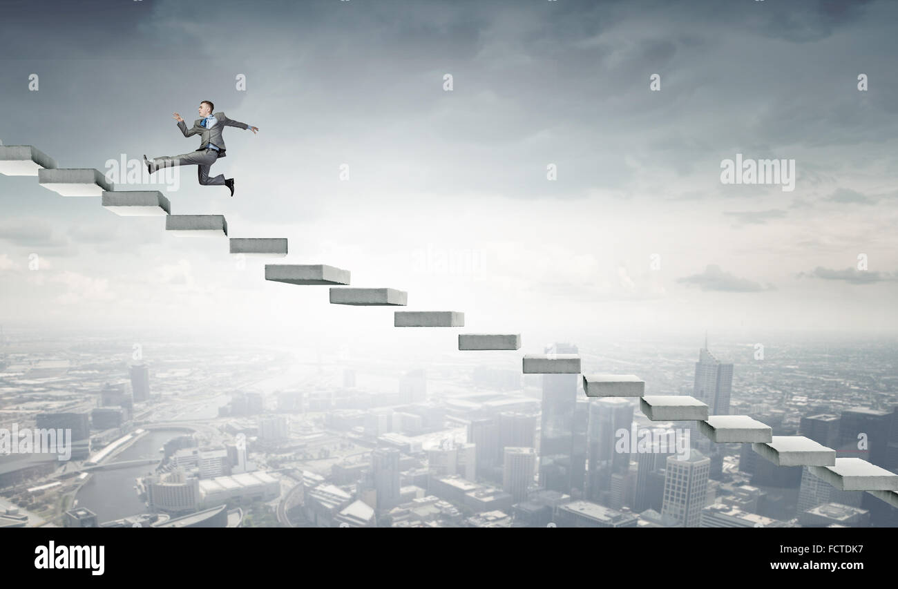 Young businessman running up on staircase representing success concept ...