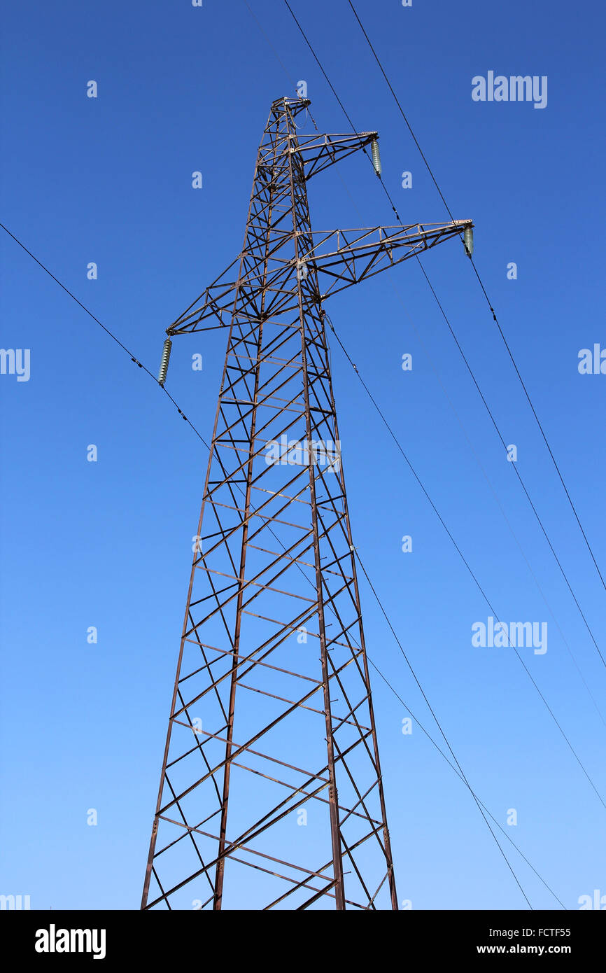 High voltage power pylons against blue sky Stock Photo - Alamy