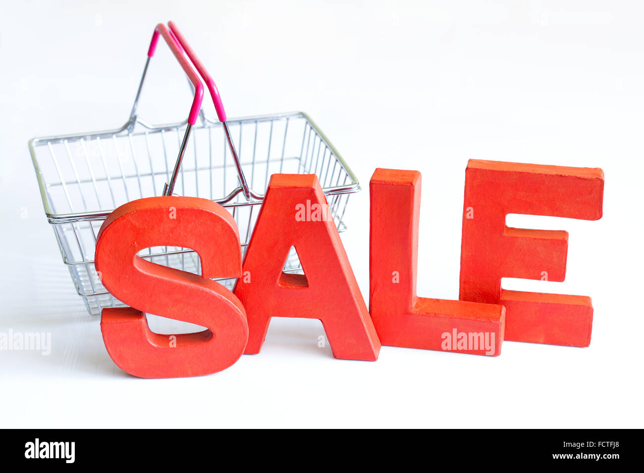 Sale red letters and a shopping basket on a white background Stock Photo