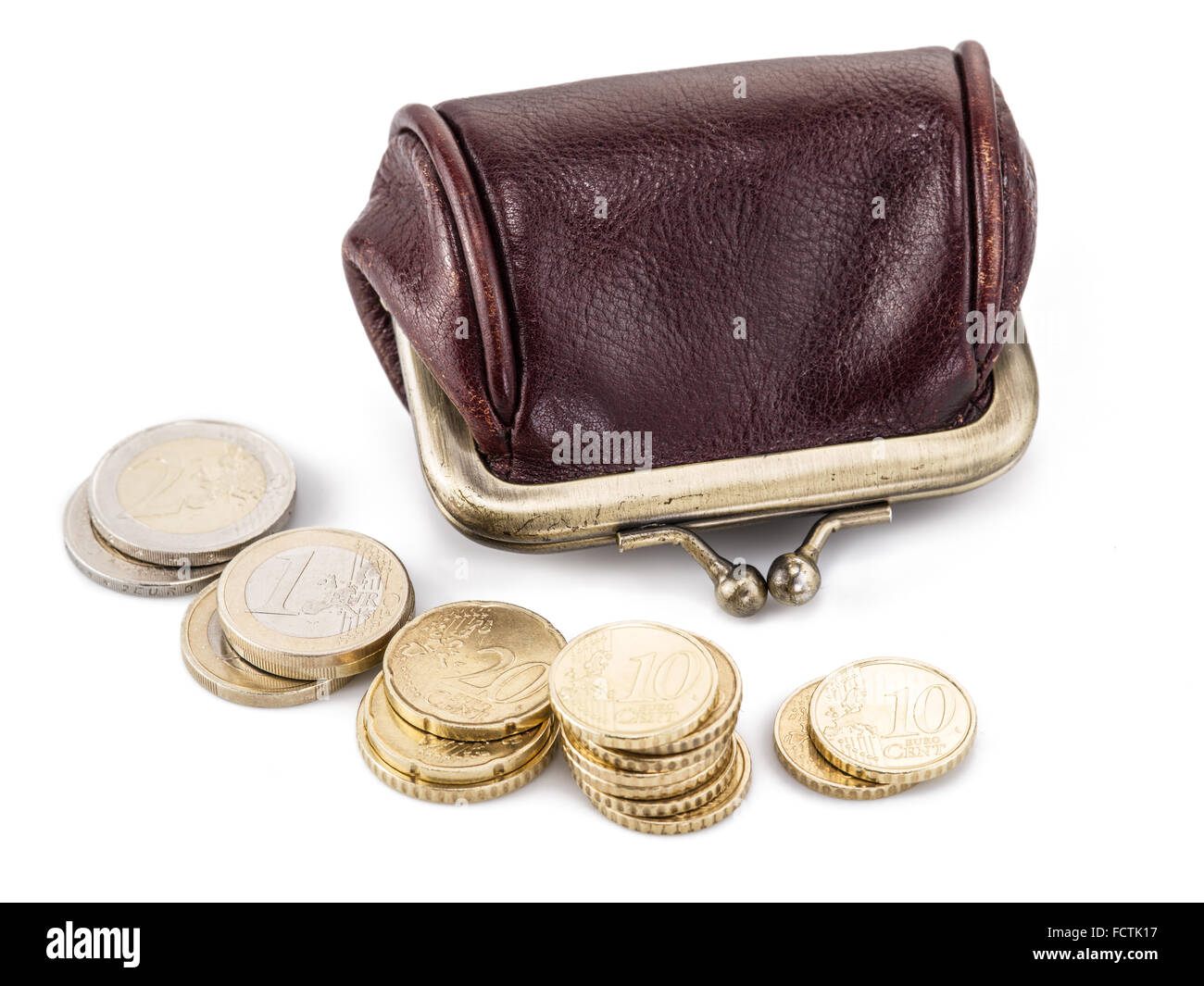 Small leather purse for coins and coins near it. Isolated on white background. Stock Photo