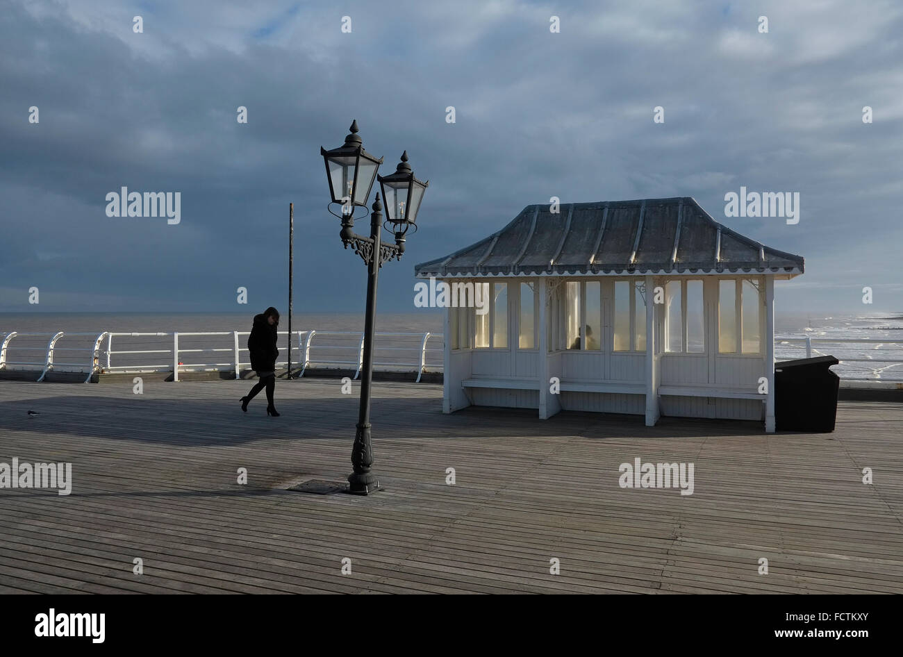 person walking in strong wind on cromer pier, north norfolk, england Stock Photo