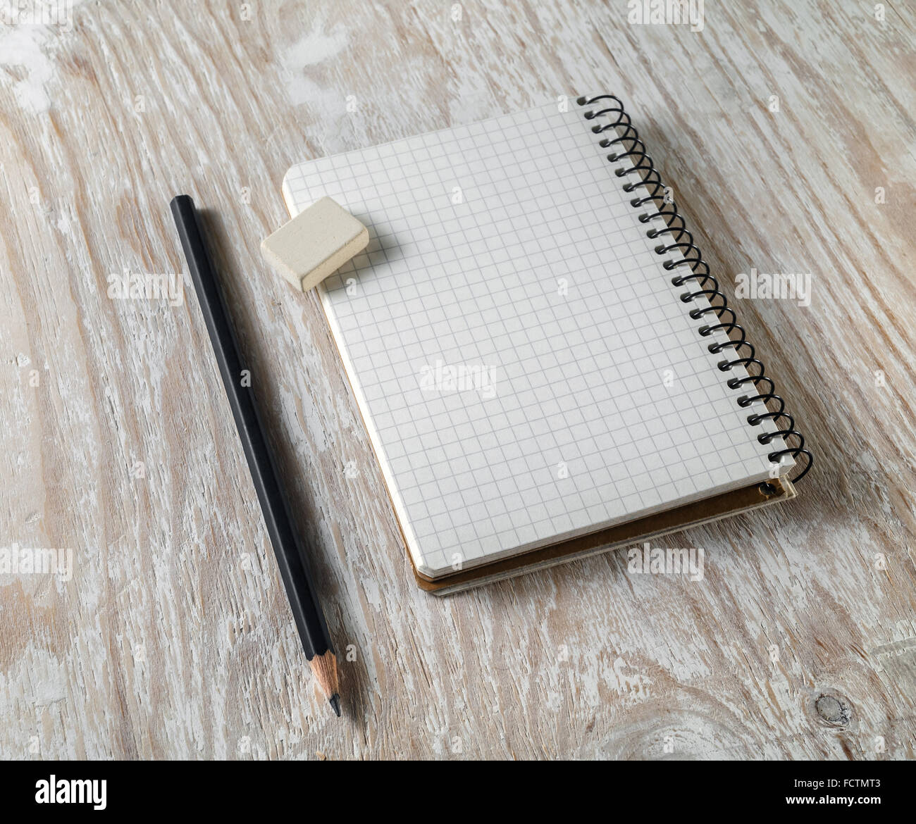 Photo of blank sketchbook with a pencil and eraser on light wooden