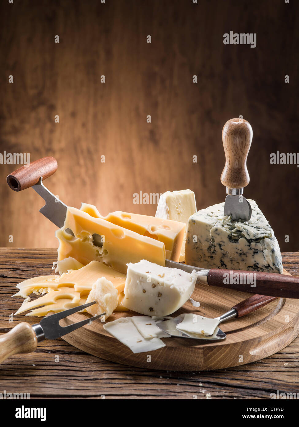 Variety of cheeses on a wooden board. Stock Photo