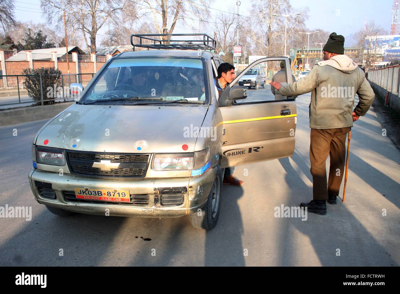 Indian police men checks a passenger  vehicle near a temporary barricade in place for surprise search operation in Srinagar, the summer capital of Indian Kashmir, 25 January 2016. Security has been beefed up in Indian Kashmir ahead of the Indian Republic Day celebrations scheduled to be held on 26 January.(Basit Zargar/ Alamy Live News) Stock Photo
