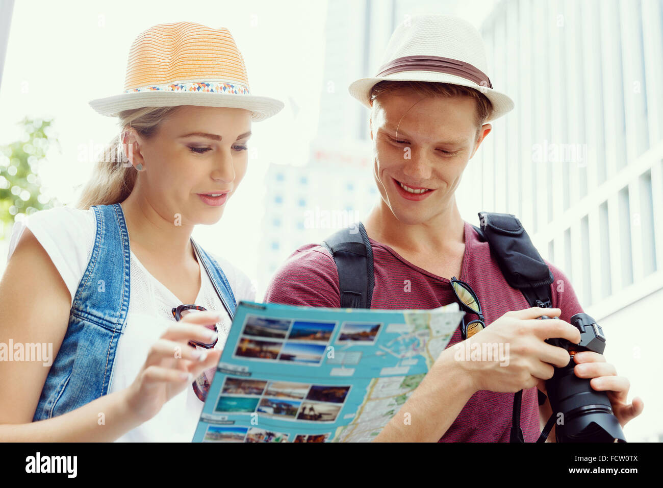 Happy young couple as tourists with a map Stock Photo - Alamy
