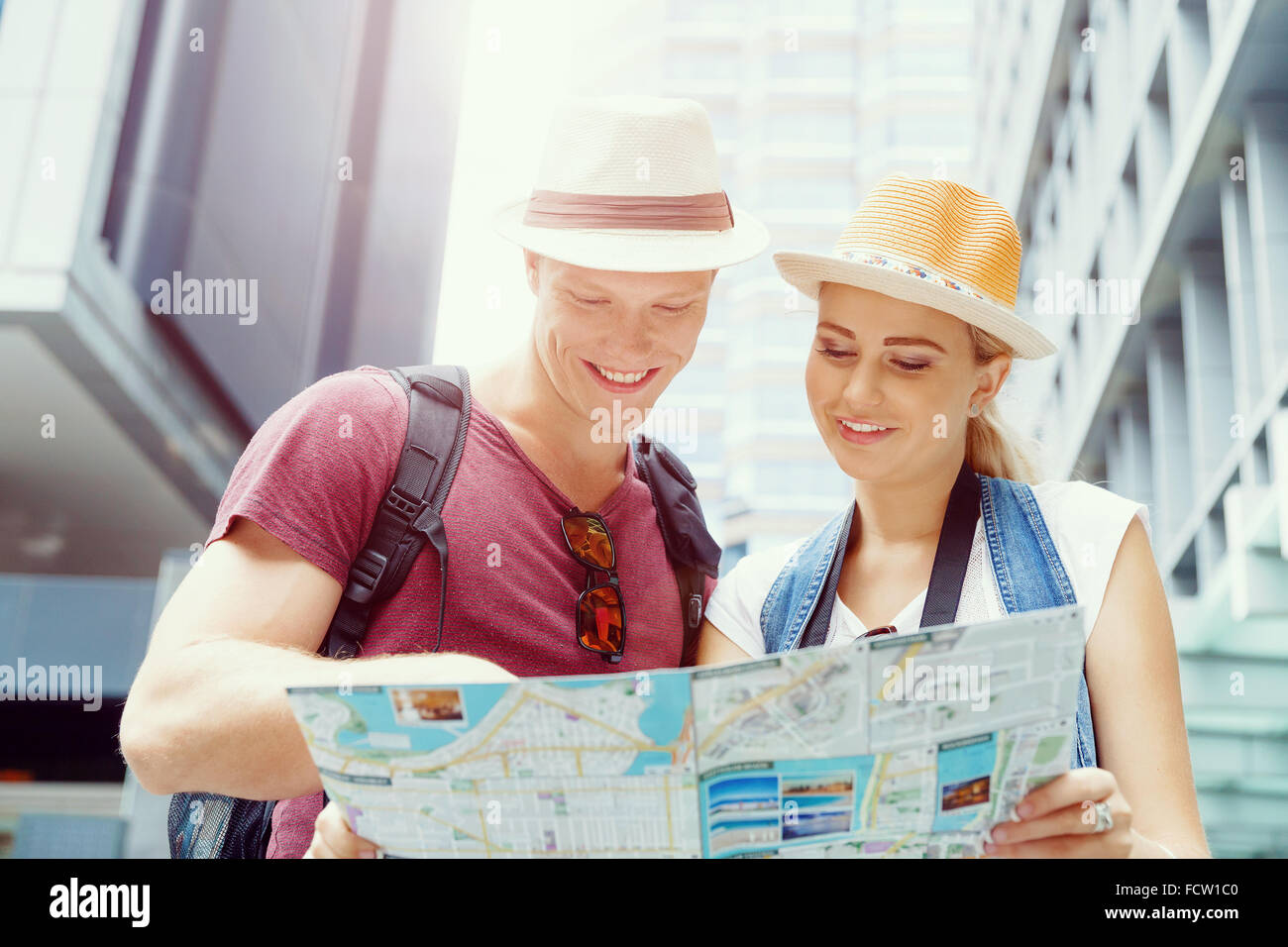 Happy young couple as tourists with a map Stock Photo - Alamy