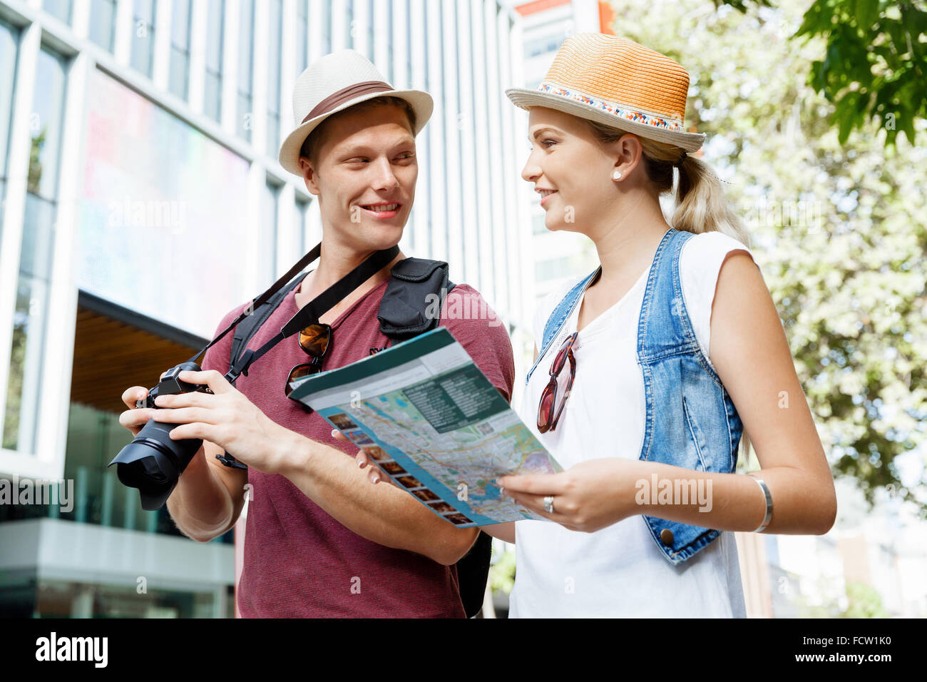 Happy young couple as tourists with a map Stock Photo - Alamy