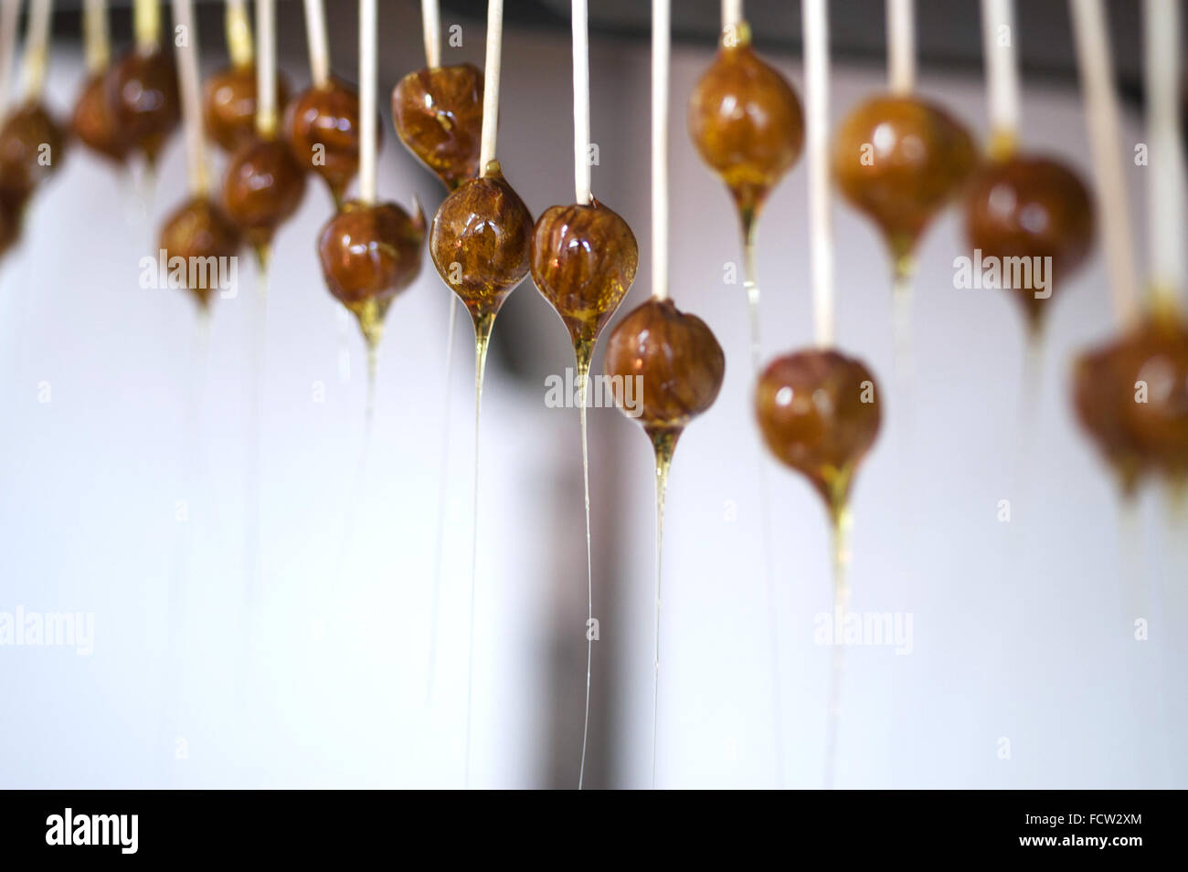 Homemade toffee lollipops hanging in kitchen Stock Photo