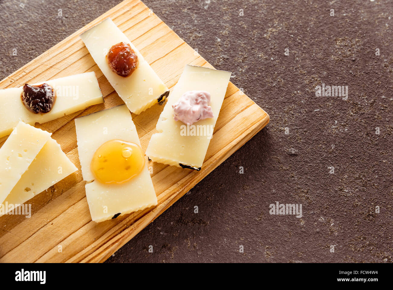 A composition of italian cheese pecorino slices with jams of different