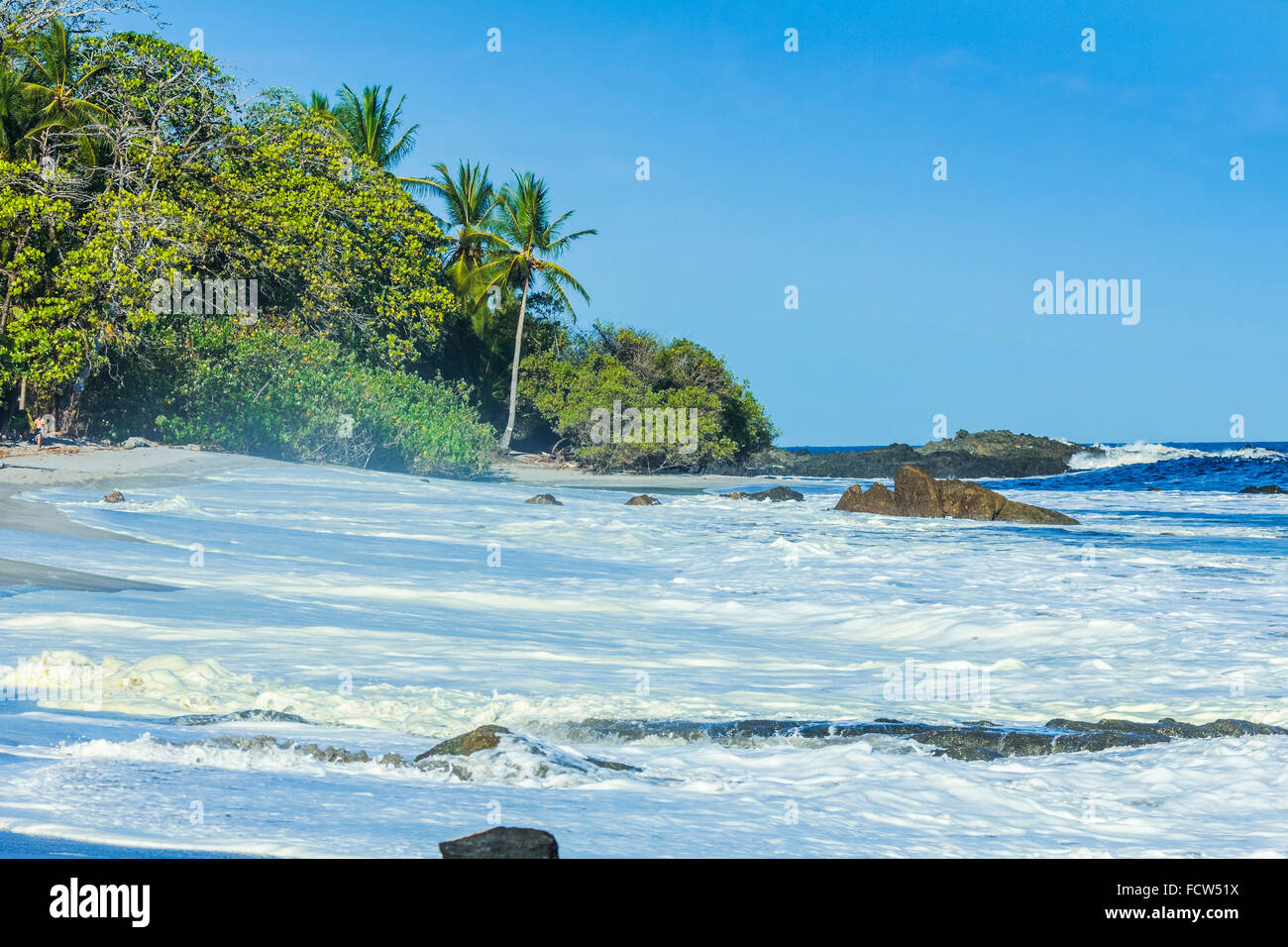 Surf & yellow algal bloom on Montezuma Beach at this resort on Nicoya Peninsula's SE tip; Montezuma, Puntarenas, Costa Rica Stock Photo