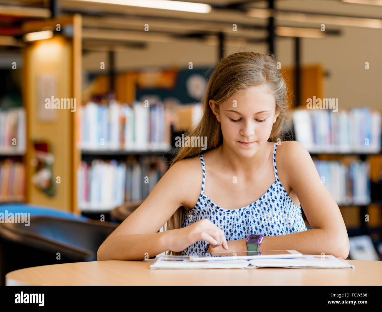 A teenage girl with a book in library Stock Photo - Alamy