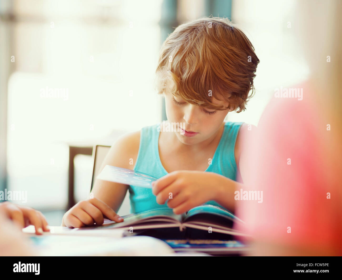 Boy in library with books Stock Photo - Alamy