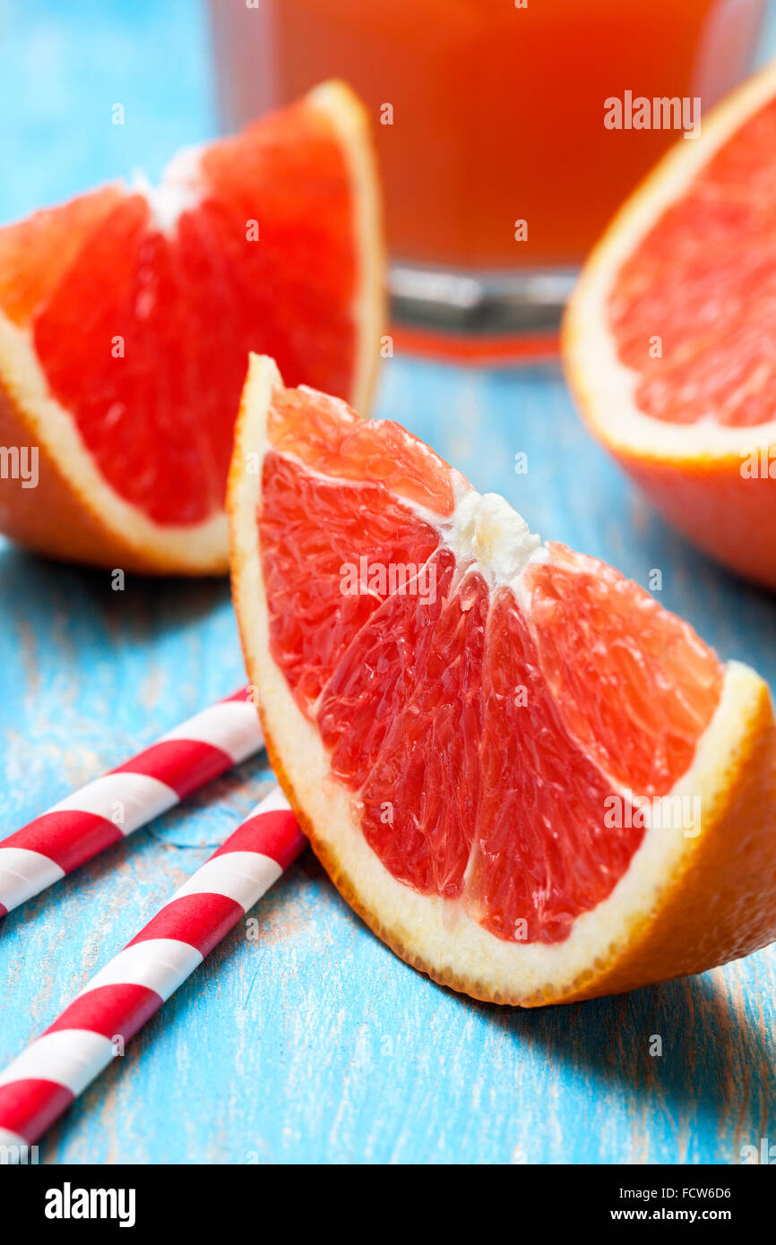 sliced grapefruit, grapefruit juice on blue wooden background Stock Photo