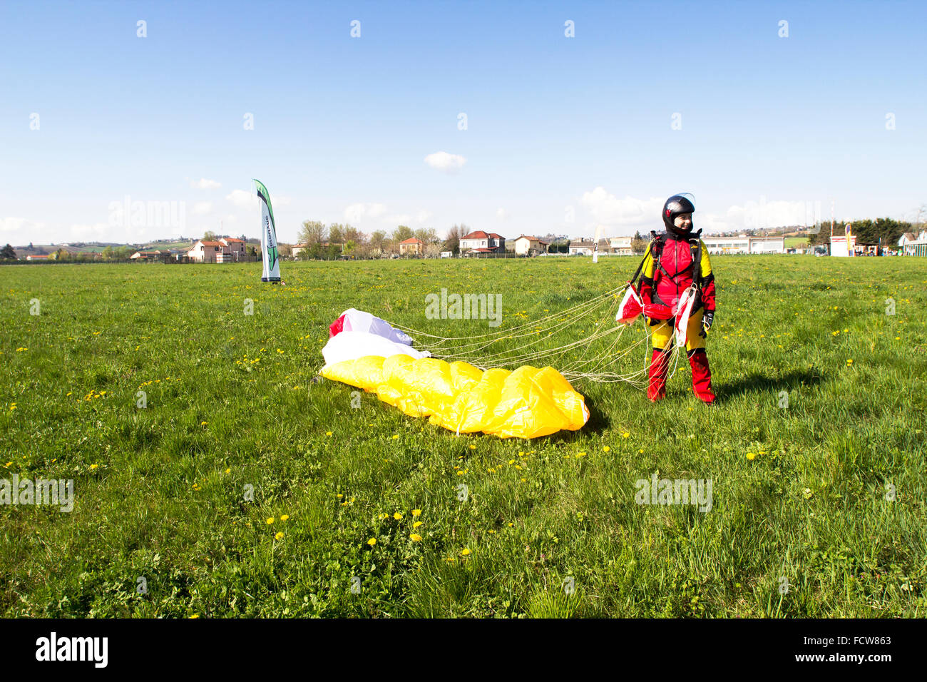 This skydiver girl landed on her feet in the dedicated grass area. She can't believe it, that she did this jump and is save now! Stock Photo