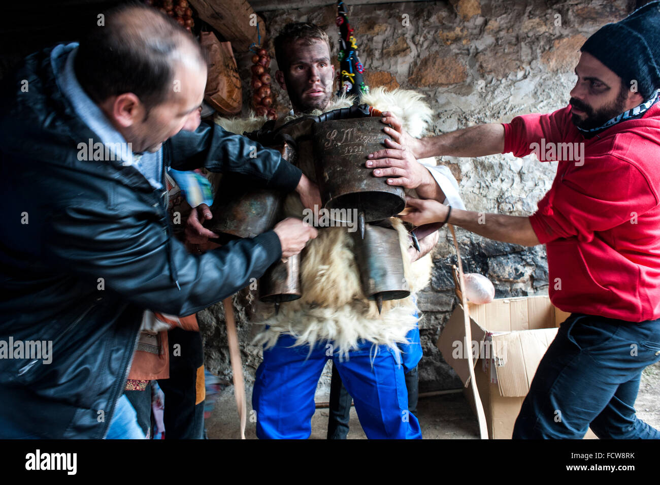 a character who plays a zarramaco is helped to get the campanos before the parade of carnival Vijanera. Stock Photo