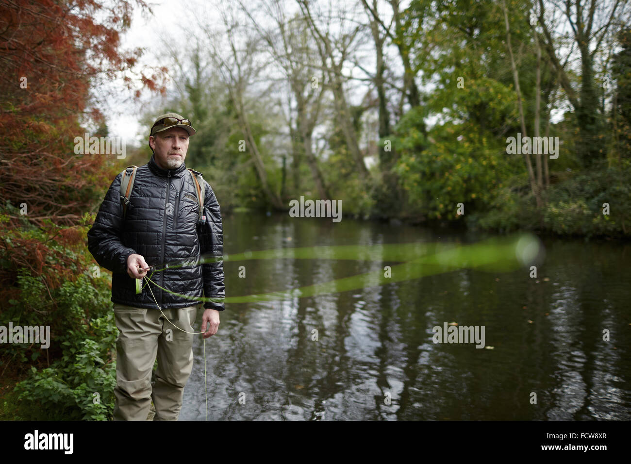 A man fly fishing in a river Stock Photo