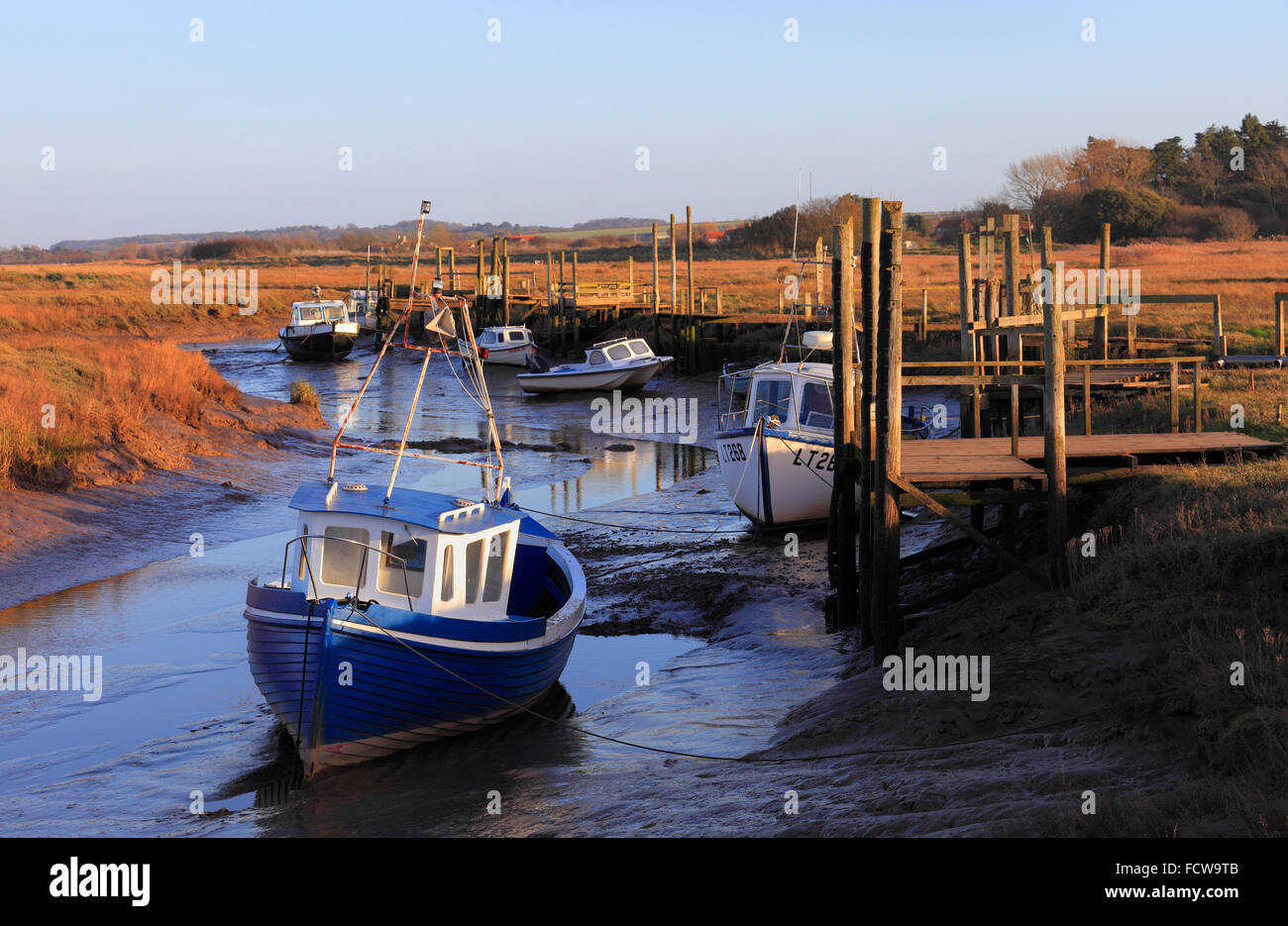 Boats and jetties at low tide at Thornham harbour on the North Norfolk
