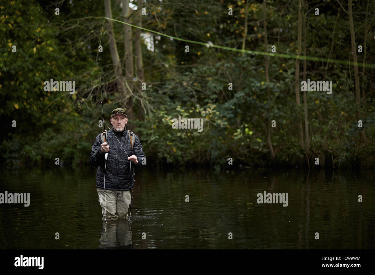 A man fly fishing in a river Stock Photo