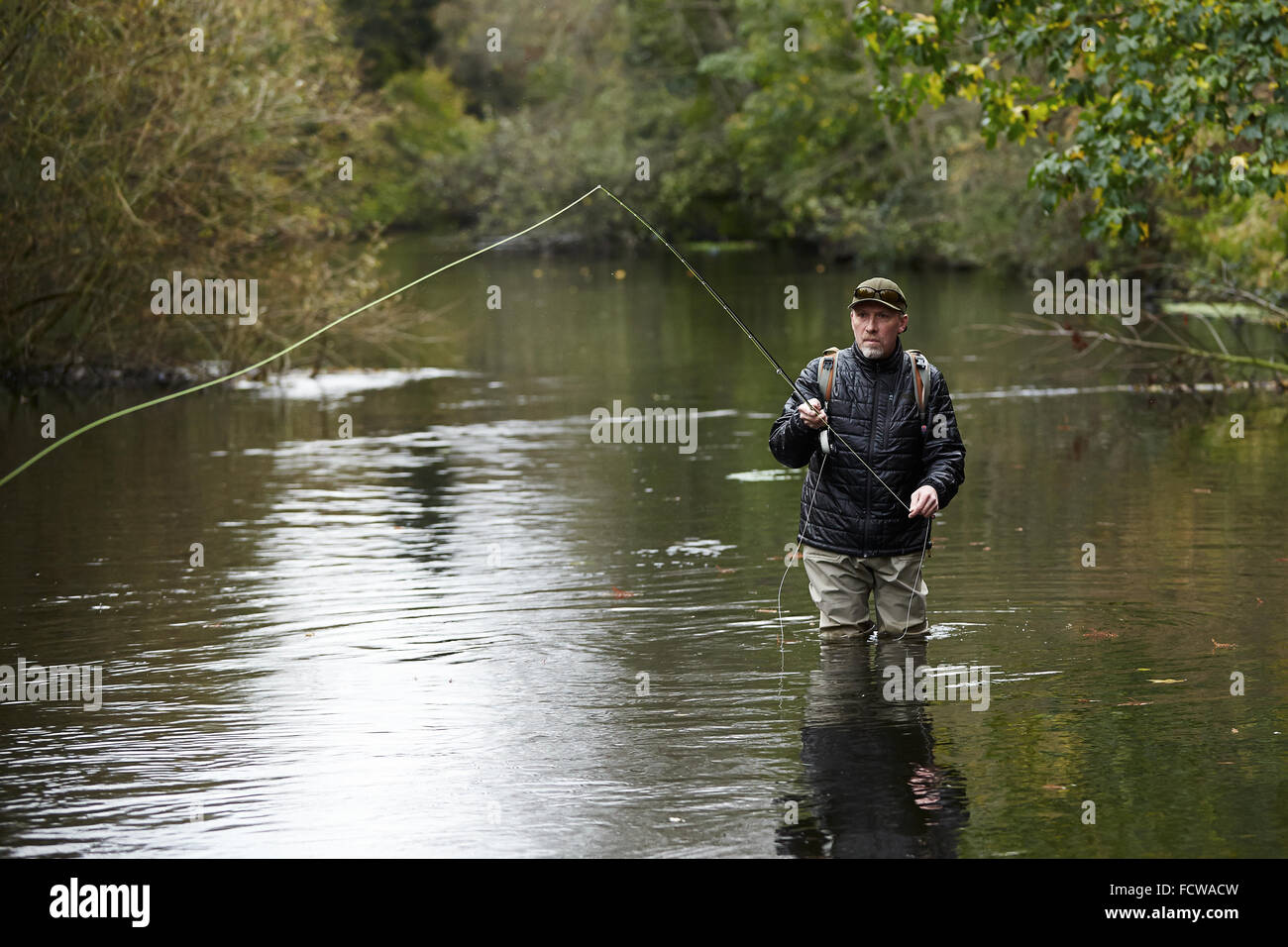 A man fly fishing in a river Stock Photo