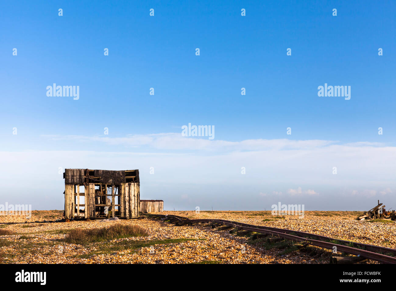Abandoned old fishing boat and transport tracks on the shingle beach at ...