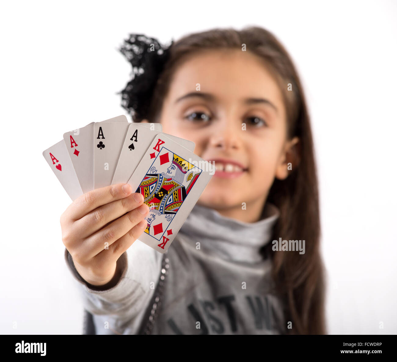 proud-little-girl-showing-a-winning-poker-hand-of-four-aces-and-a-FCWDRP.jpg