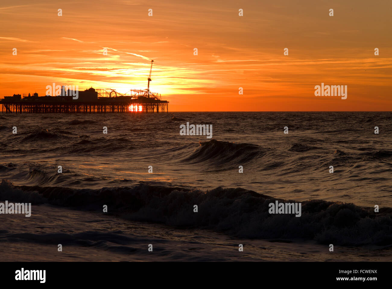 Sun rising beneath Brighton Pier Stock Photo - Alamy