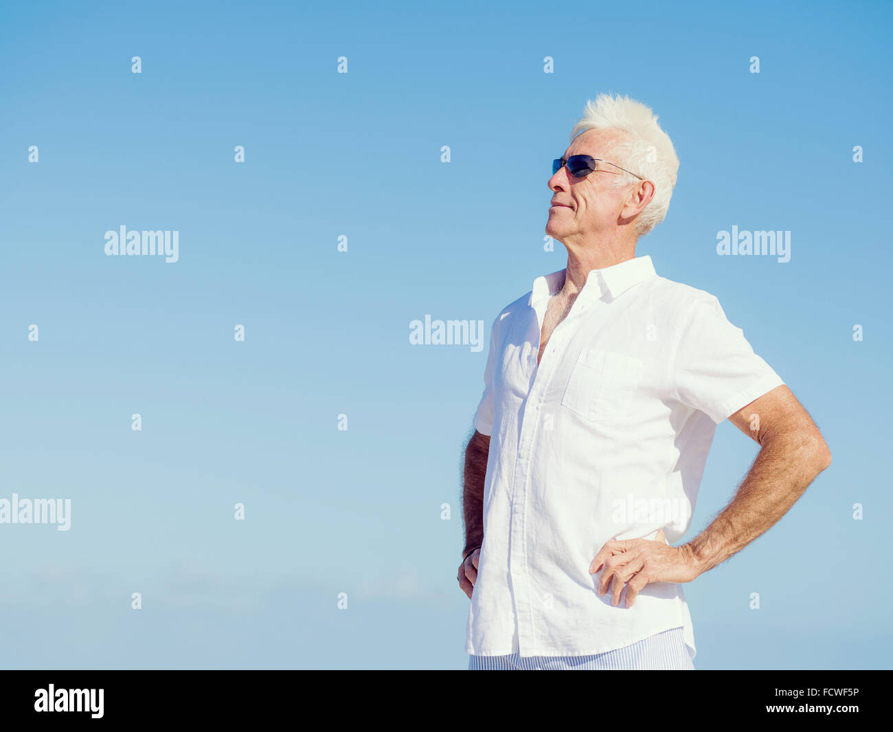 Handsome man against blue sky Stock Photo - Alamy