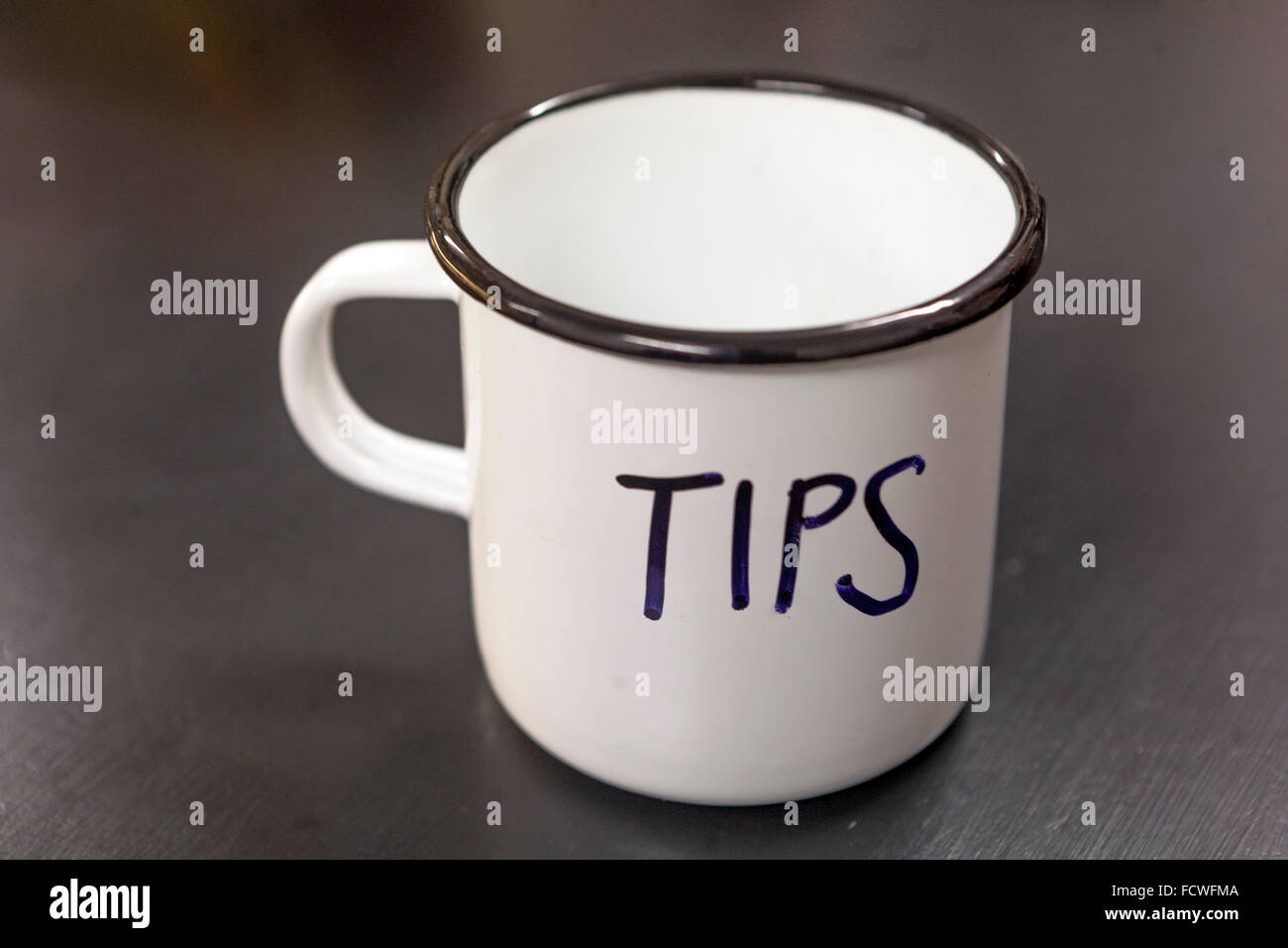 White metal mug with the inscription tips Stock Photo