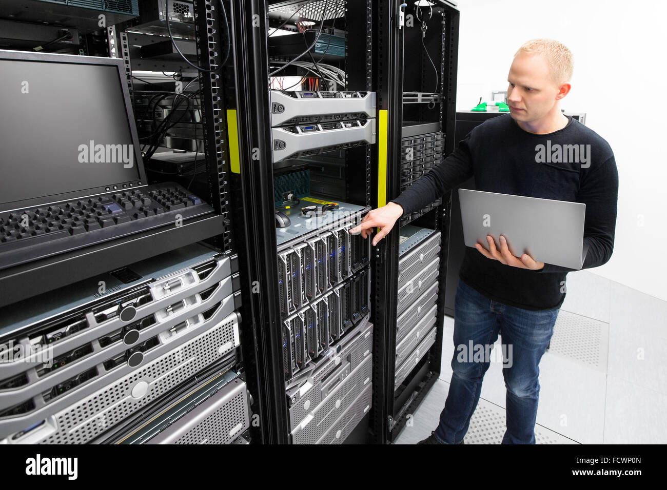 It consultant monitors blade servers in datacenter Stock Photo