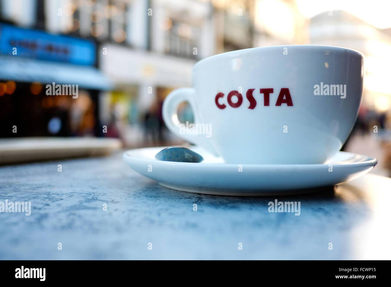 A costa coffee cup on an outside table clearly showing the costa logo on the cup Stock Photo