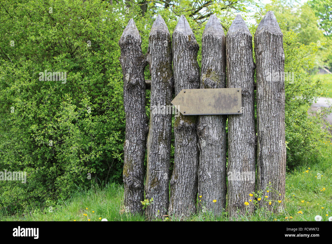 Part of an ancient wooden fence with directional sign Stock Photo - Alamy