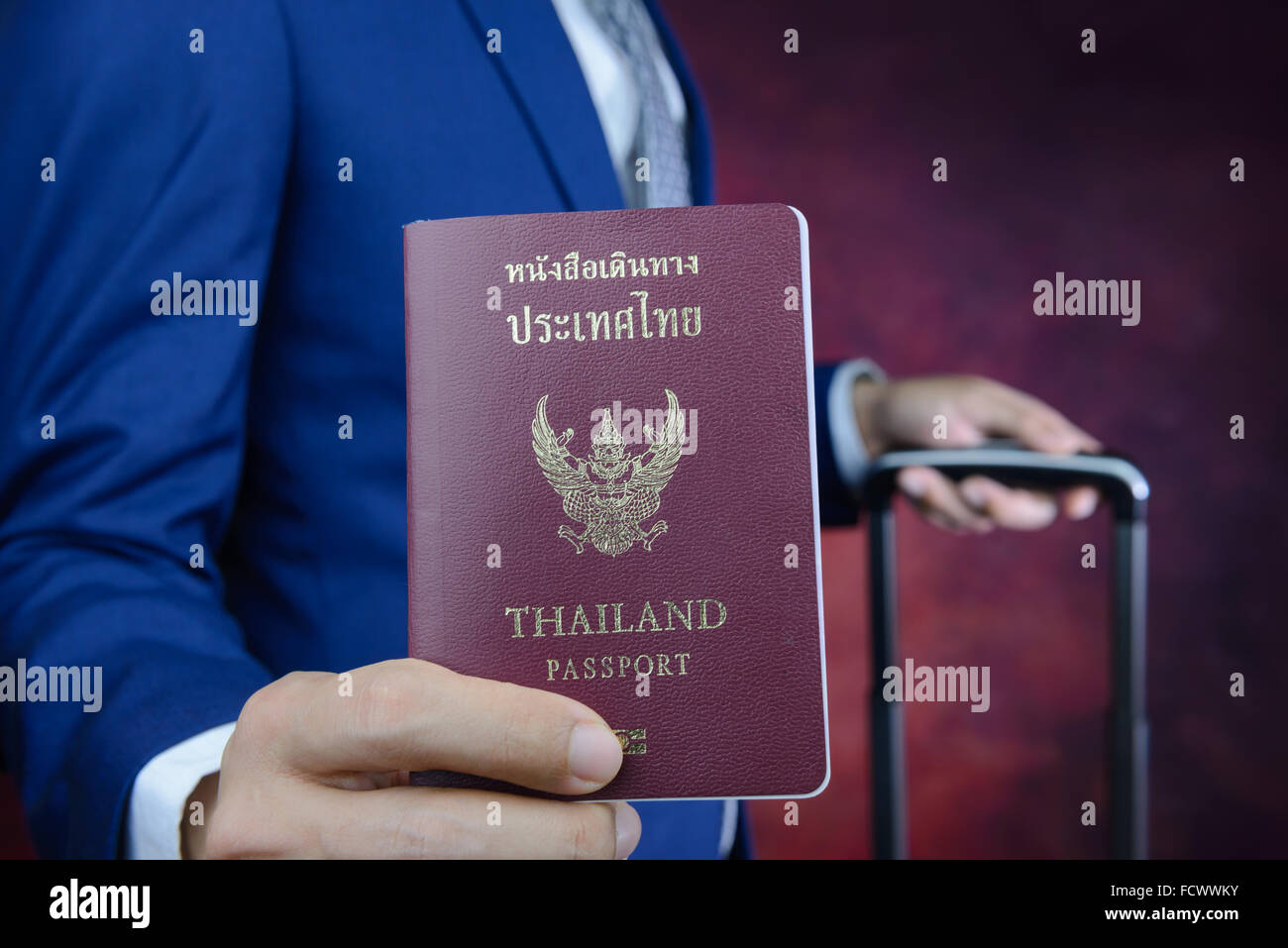 businessman in blue suit showing passport with suitcase Stock Photo Alamy