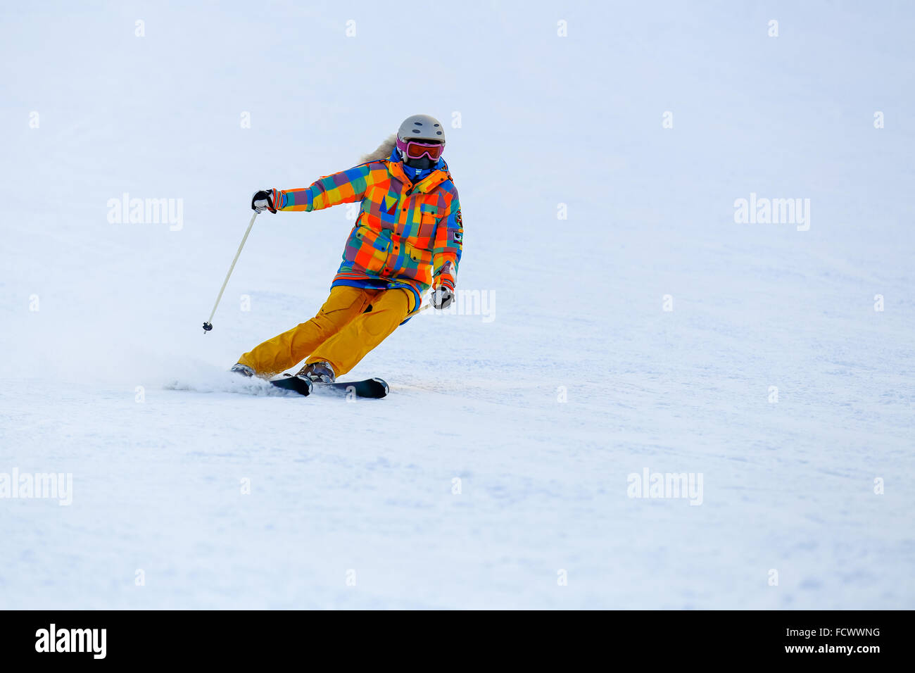 Skier skiing in fresh snow on ski slope Stock Photo