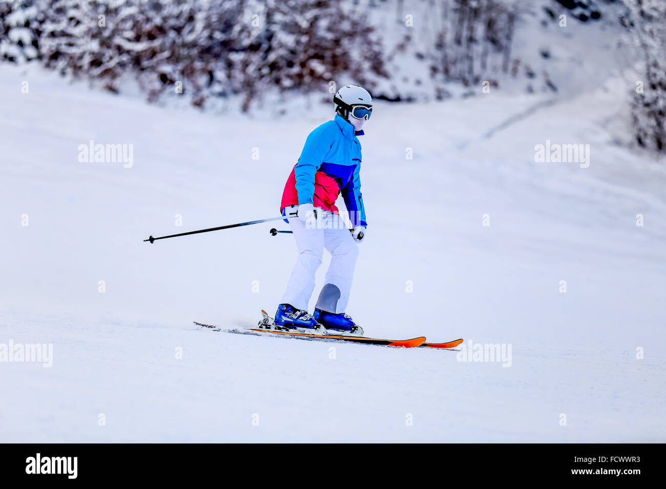 Woman in white skiing suit on mountain slope Stock Photo