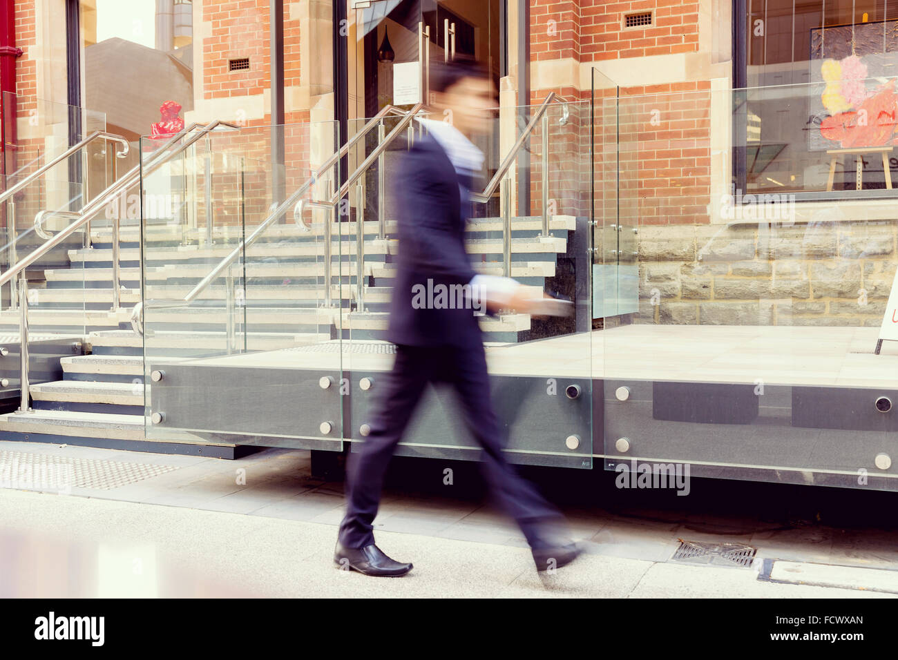 Blurred image of businessman walking in city Stock Photo - Alamy