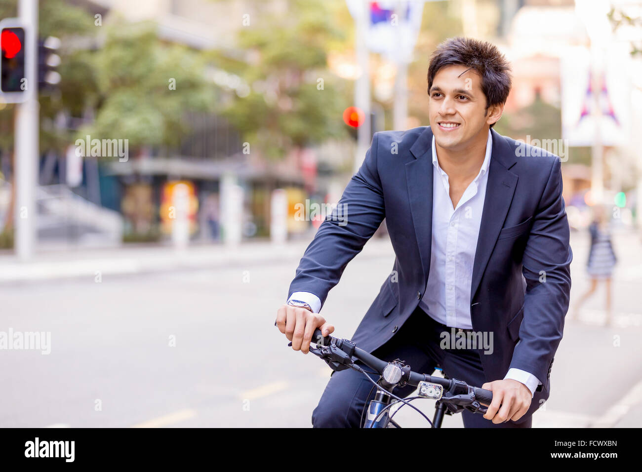 Successful businessman in suit riding bicycle Stock Photo