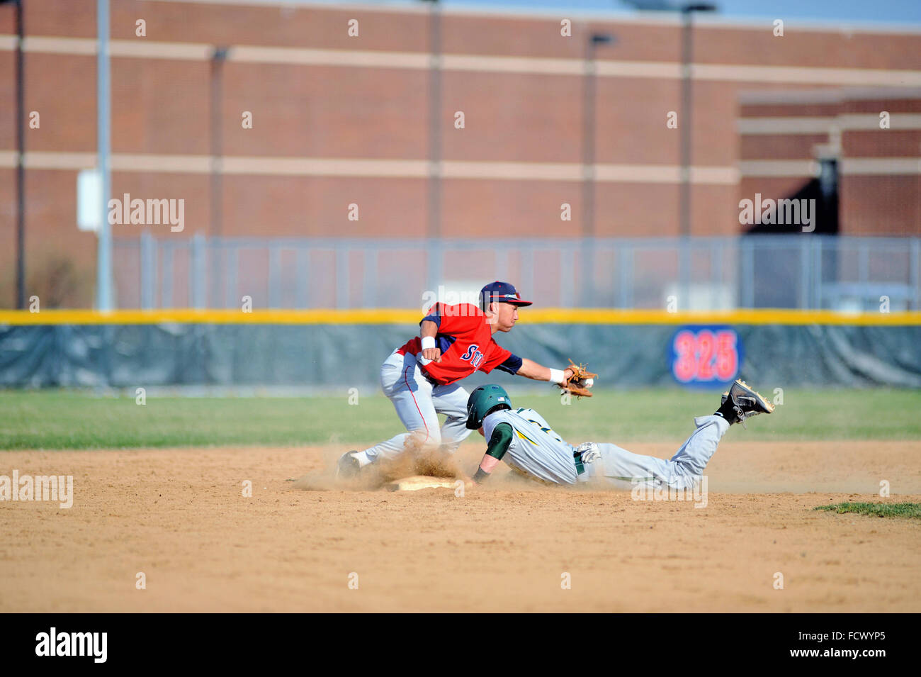 High school base runner slides safely into second base with a stolen