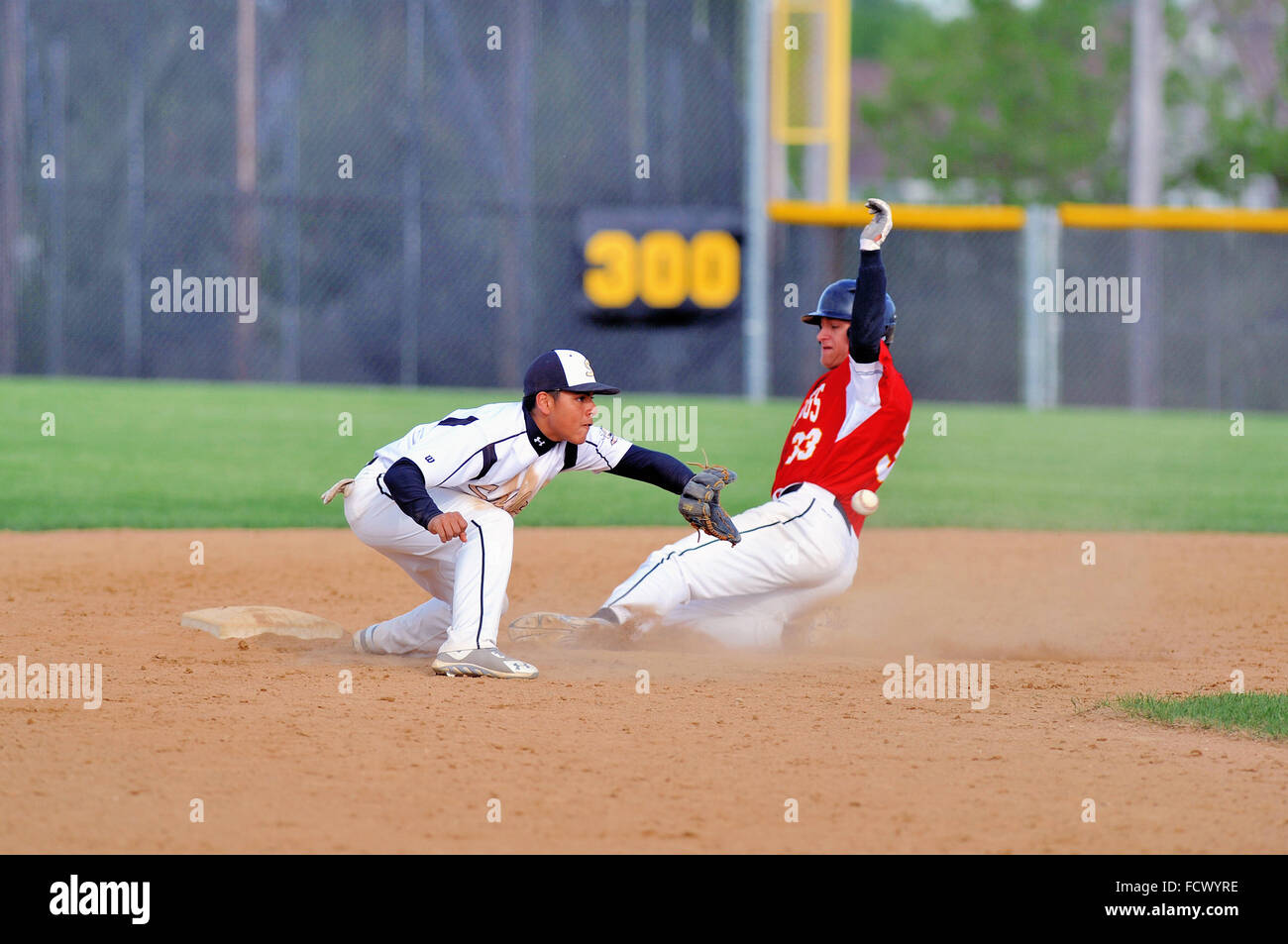 High school base runner slides safely into second base with a stolen