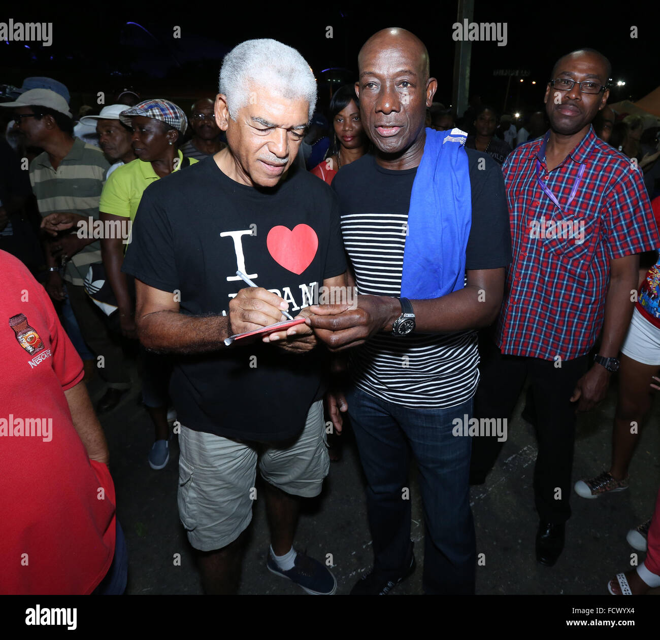 Port of Spain, Trinidad. 24th January, 2016. Keith Christopher Rowley (C), Prime Minister of Trinidad & Tobago, talks with famed steel pan arranger Ray Holman at the semi-finals of Panorama in the Queen's Park Savannah during Carnival in Port of Spain, Trinidad on Sunday January 24, 2016. (Photo by Sean Drakes/Alamy Live News) Stock Photo