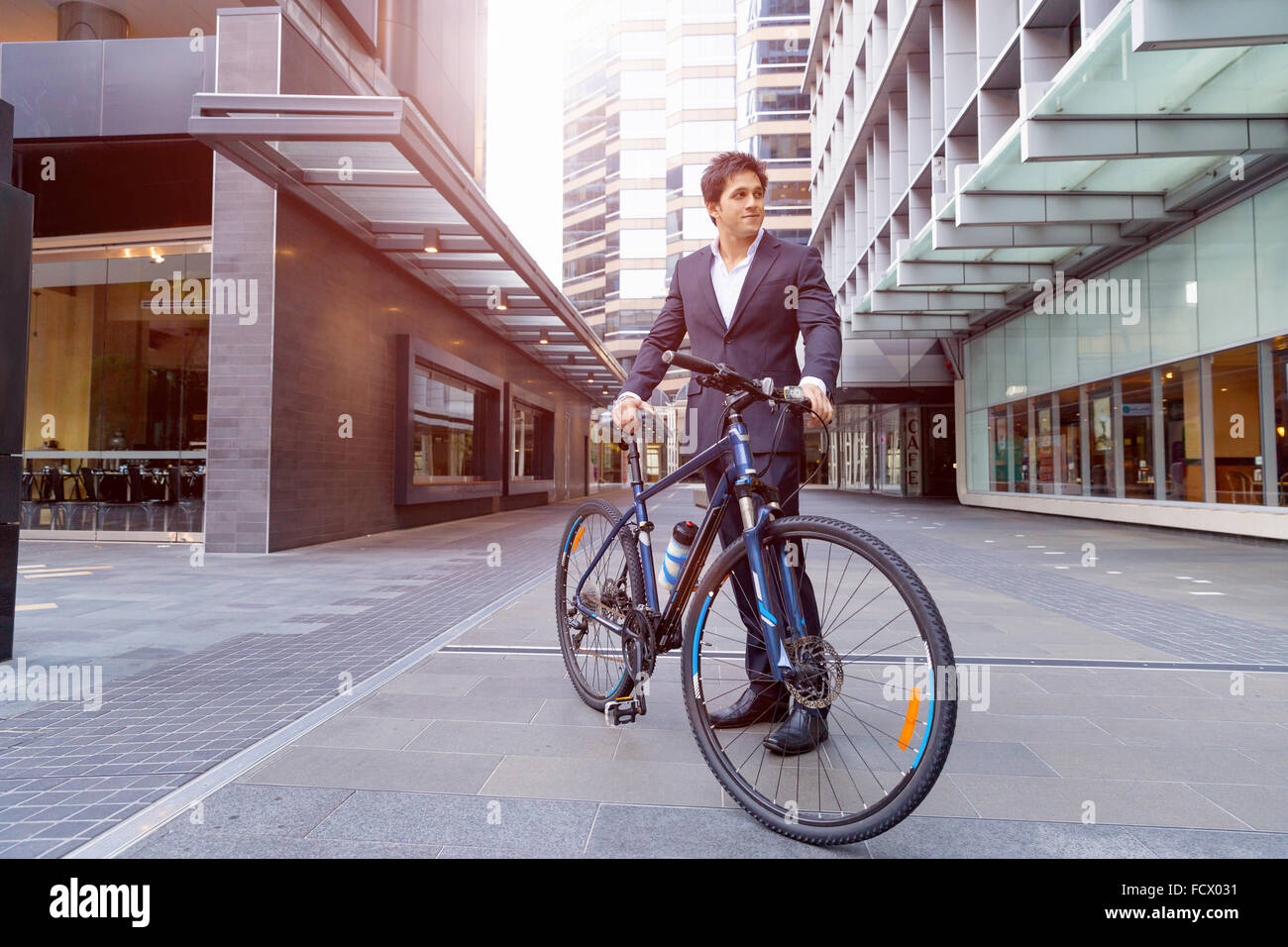 Successful businessman in suit with bicycle in city Stock Photo