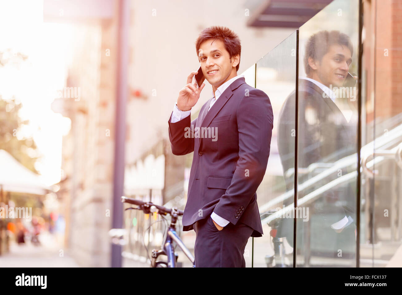 Successful businessman in suit with bicycle in city Stock Photo - Alamy