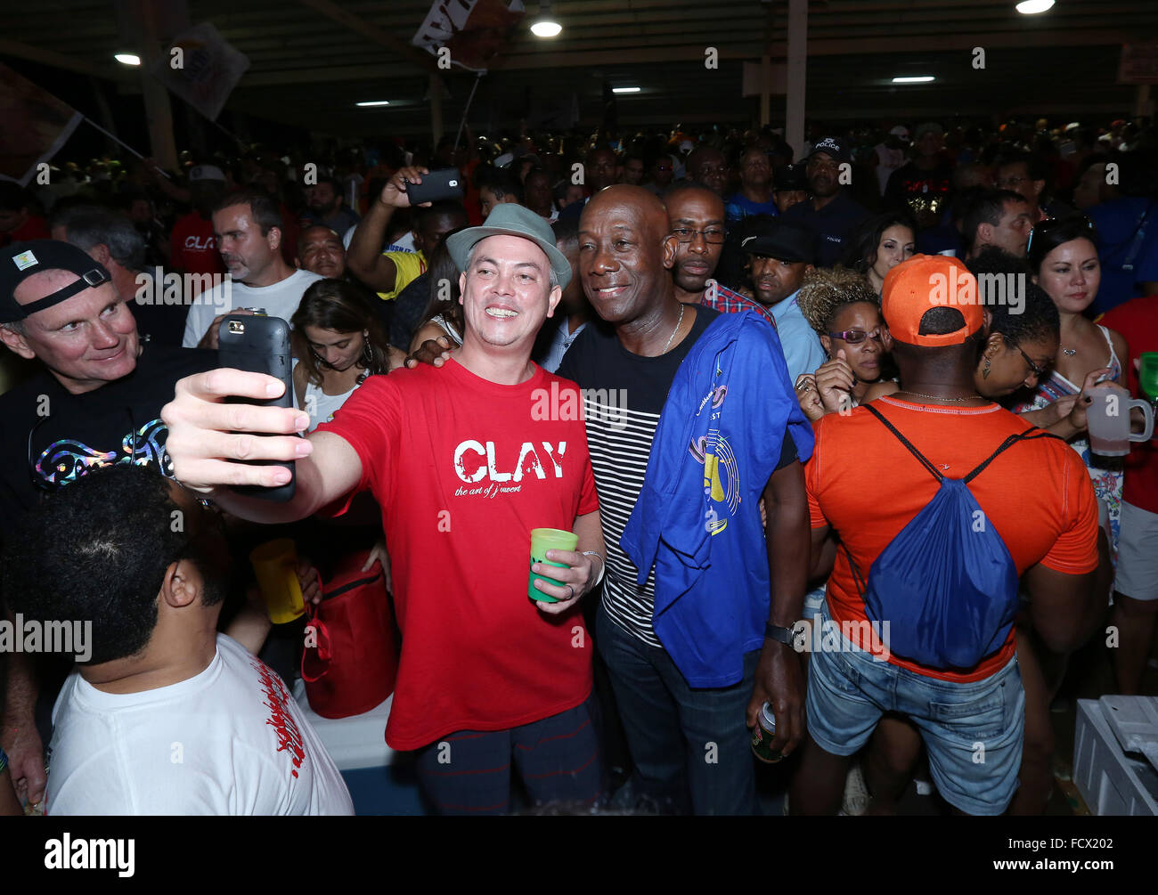 Port of Spain, Trinidad. 24th January, 2016. Keith Christopher Rowley (C), Prime Minister of Trinidad & Tobago, poses for selfies in the North Stand at the semi-finals of Panorama in the Queen's Park Savannah during Carnival in Port of Spain, Trinidad on Sunday January 24, 2016. (Photo by Sean Drakes/Alamy Live News) Stock Photo