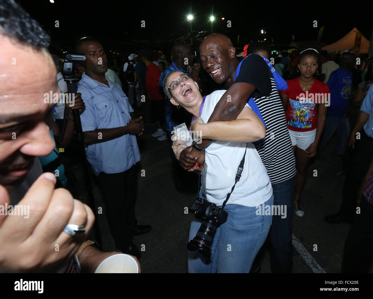 Port of Spain, Trinidad. 24th January, 2016. Keith Christopher Rowley (C), Prime Minister of Trinidad & Tobago, hugs Maria Nunes at the semi-finals of Panorama in the Queen's Park Savannah during Carnival in Port of Spain, Trinidad on Sunday January 24, 2016. (Photo by Sean Drakes/Latin Content/Getty Images) Stock Photo